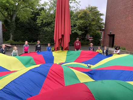 Kinder spielen mit einem Schwungtuch